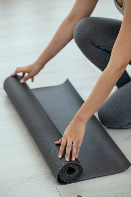 Woman practicing a supported yoga fish pose using two blocks on a light mat indoors.